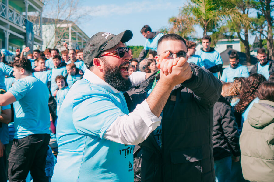 Jóvenes festejando al aire libre con remeras celestes