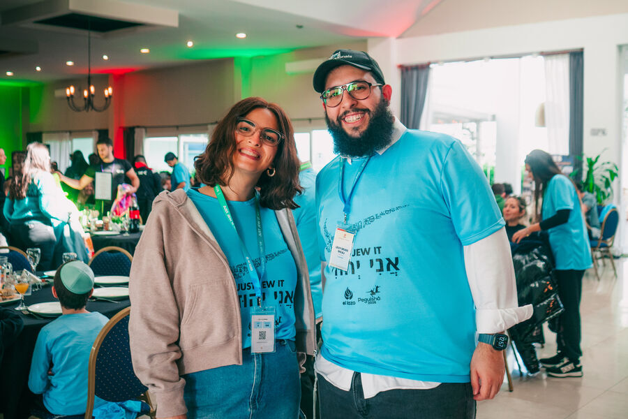 Dos personas sonriendo en un encuentro con remeras celestes